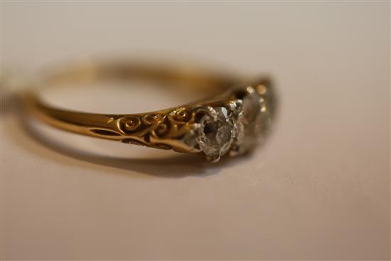 An Edwardian 18ct gold and graduated three stone diamond ring, size O.